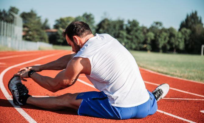 man stretching on a track